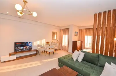 a living room with a green couch and a table at Studio 01 Maarif - High Speed Wi-Fi in Casablanca