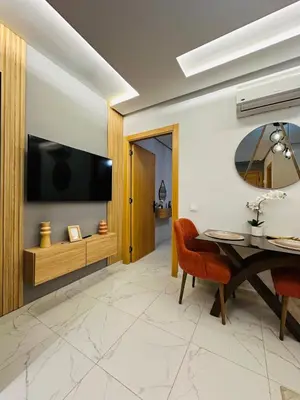 a dining room with a table and a television at Studio moderne et accueillant, pour se reposer 14 in Casablanca