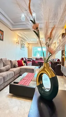 a living room with a vase with flowers on a table at Grand 3 pièces de standing, confort premium in Casablanca