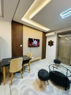 a living room with a table and chairs and a tv at Studio tout équipé pour un séjour confortable 22 in Casablanca