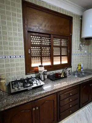 a kitchen counter with a stove and a sink at Appartement confortable à Rabat, idéalement situé près de la Corniche et du Stade in Rabat