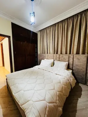 a bedroom with a large white bed with curtains at Appartement confortable à Rabat, idéalement situé près de la Corniche et du Stade in Rabat