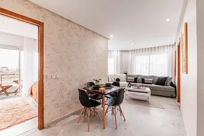 a dining room with a table and chairs and a living room at Apartment in the center of Casablanca opposite the tram in Casablanca