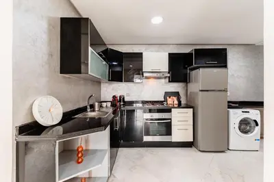 a kitchen with black and stainless steel appliances at Apartment in the center of Casablanca opposite the tram in Casablanca