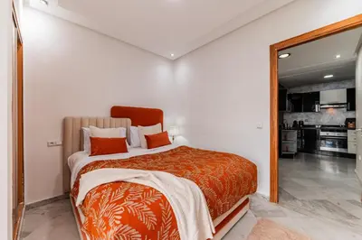 a bedroom with a bed with orange pillows and a mirror at Apartment in the center of Casablanca opposite the tram in Casablanca