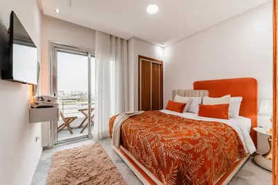 a bedroom with a bed and a balcony at Apartment in the center of Casablanca opposite the tram in Casablanca