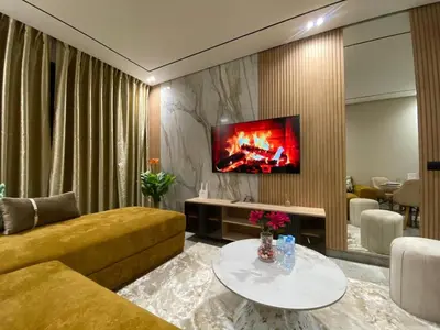 a living room with a couch and a tv on a wall at Beau Living Park Residence Bright Central Cosy Apartment Beauséjour Centre De Casablanca En Face De Anfa Park in Casablanca