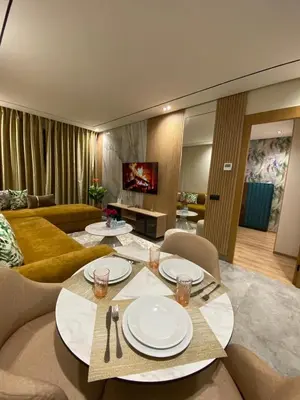 a living room with a table with plates on it at Beau Living Park Residence Bright Central Cosy Apartment Beauséjour Centre De Casablanca En Face De Anfa Park in Casablanca