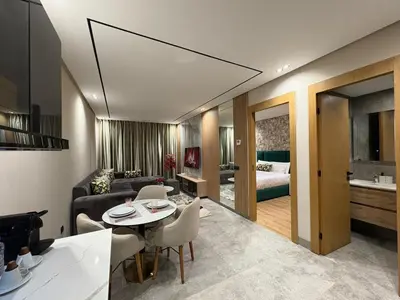 a living room with a table and a room with a bed at Beau Living Residence Central Cosy Apartment In The Heart Of Casablanca Close To Anfa Park Calm Area in Casablanca