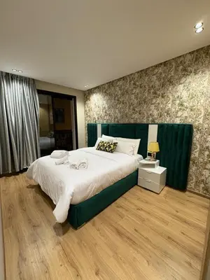 a bedroom with a large bed with a green headboard at Beau Living Residence Central Cosy Apartment In The Heart Of Casablanca Close To Anfa Park Calm Area in Casablanca