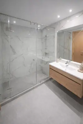 a bathroom with a glass shower and a sink at Central Modern Apartment Agdal TGV Train Station in Rabat
