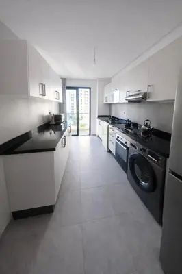 a large kitchen with a washer and dryer in it at Central Modern Apartment Agdal TGV Train Station in Rabat