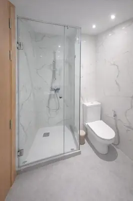 a bathroom with a glass shower and a toilet at Central Modern Apartment Agdal TGV Train Station in Rabat