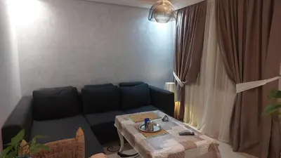 a living room with a couch and a table at Cocon & Confort in Dar Ben Abdallah Ben Dehbi