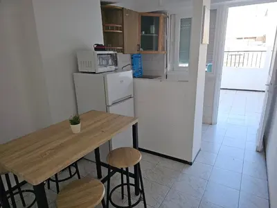 a kitchen with a table and a refrigerator and stools at Superbe studio a avenue france agdal in Rabat