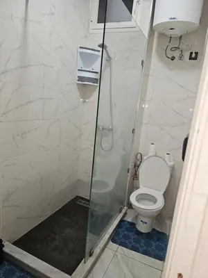 a bathroom with a toilet and a glass shower at Superbe studio a avenue france agdal in Rabat