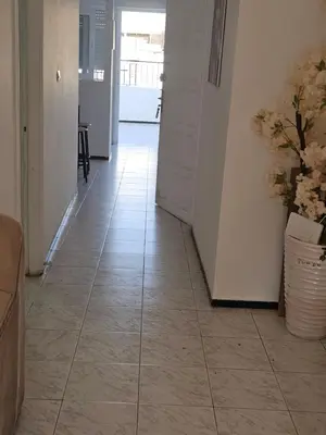 a hallway with a tile floor and flowers on the wall at Superbe studio a avenue france agdal in Rabat