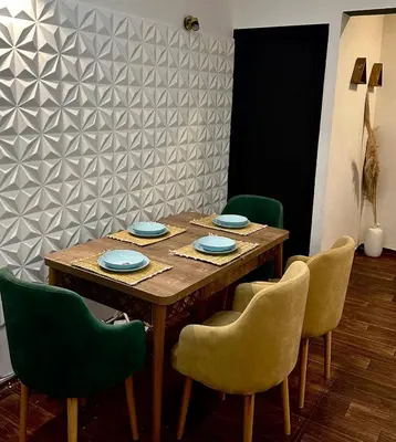 a dining room with a wooden table and green chairs at appartement au coeur de Rabat in Rabat