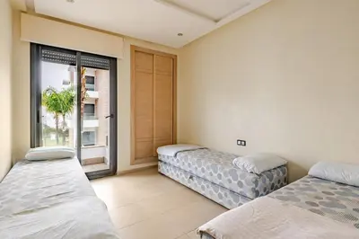 two beds in a room with a window at Cosy 2 Bedrooms Skhirat Residence in Skhirat