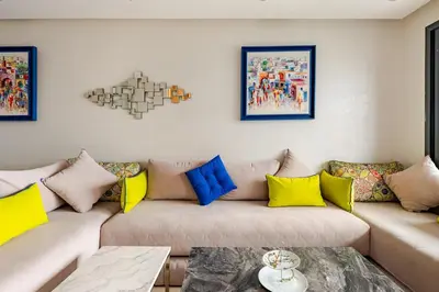 a living room with a couch with colorful pillows at Cosy 2 Bedrooms Skhirat Residence in Skhirat