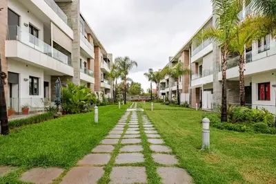 a walkway in the middle of a lawn with buildings at Cosy 2 Bedrooms Skhirat Residence in Skhirat