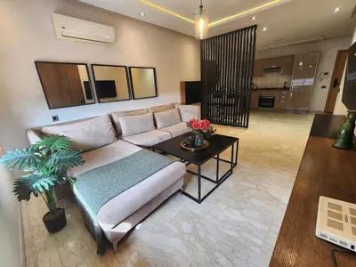 a living room with a couch and a table at Modern Studio Panoramic View with Wi-Fi et Parking in LʼOasis