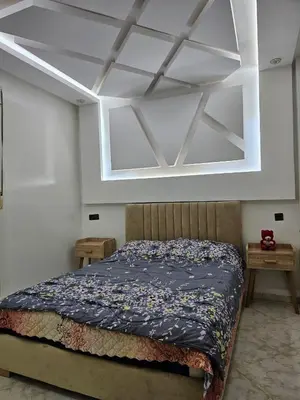 a bedroom with a bed and a white ceiling at Bouznika in Bouznika