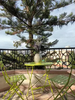 a table and chairs with a vase on top of it at Villa stade Moulay Abdellah in Temara
