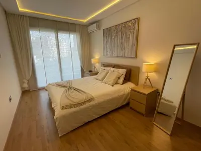 a bedroom with a large bed and a mirror at Appartement Piscine Gare Oasis in Casablanca