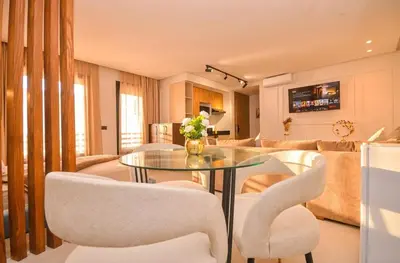 a living room with a glass table and white chairs at Studio 09 Maarif - High Speed Wi-Fi in Casablanca