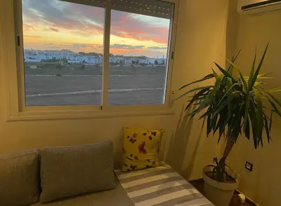 a living room with a window and a plant at Bright and cozy studio in Tamaris Beach in Tamaris