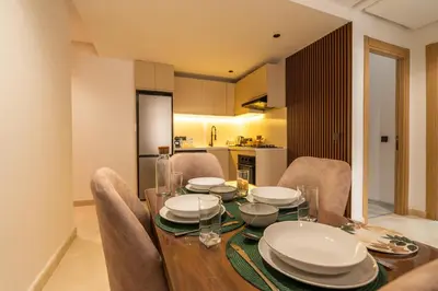 a dining room with a table and chairs and a kitchen at Maarif Premium 2 Bedrooms 2 Bathrooms La Reine II in Casablanca