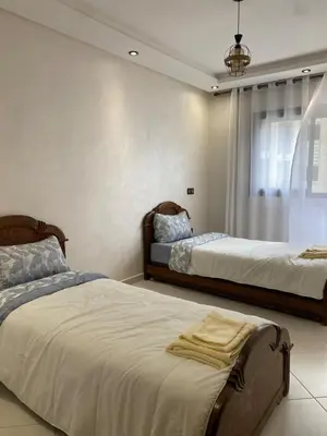 a bedroom with two beds and a window at Apartment in Bouznika with pool in Bouznika