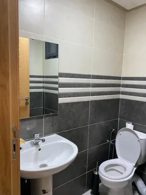 a bathroom with a white toilet and a sink at Apartment in Bouznika with pool in Bouznika