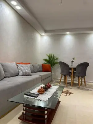 a living room with a couch and a table at Apartment in Bouznika with pool in Bouznika