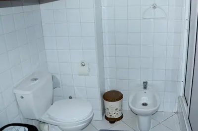 a white bathroom with a toilet and a bidet at Appartement familial convivial in Rabat
