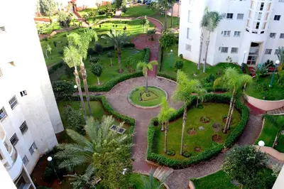 an aerial view of a park with palm trees and buildings at Appartement familial convivial in Rabat