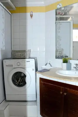 a washing machine in a kitchen next to a sink at Appartement familial convivial in Rabat