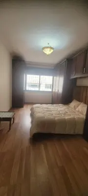 a bedroom with a large bed and a large window at Grand appartement avec une belle vue in Rabat