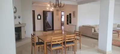 a dining room with a wooden table and chairs at Grand appartement avec une belle vue in Rabat