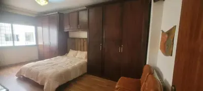 a bedroom with a bed and a large wooden cabinet at Grand appartement avec une belle vue in Rabat