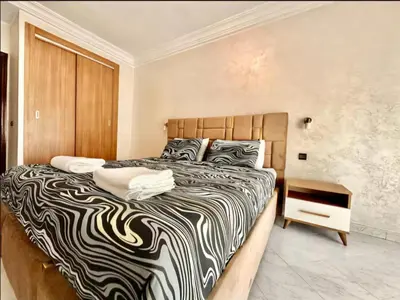 a bedroom with a large bed with a zebra print blanket at Rome Avenue Luxury Residence, 3 Chambres in Casablanca