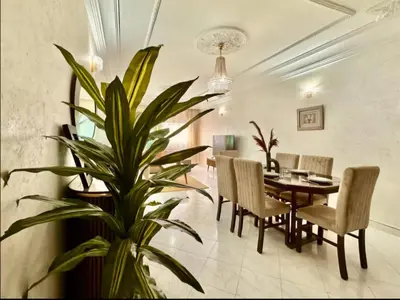 a dining room with a table and a plant at Rome Avenue Luxury Residence, 3 Chambres in Casablanca