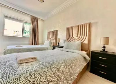 a bedroom with two beds and a window at Rome Avenue Luxury Residence, 3 Chambres in Casablanca