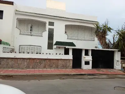 a white house with two windows and a garage at Villa harhora in Temara