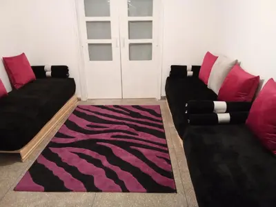 a living room with two couches and a rug at Villa harhora in Temara