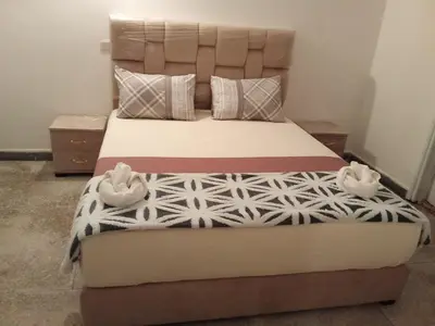 a bed in a bedroom with two shoes on it at Villa harhora in Temara