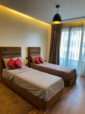 a bedroom with two beds with red pillows at Séjour Premium Casablanca in LʼOasis