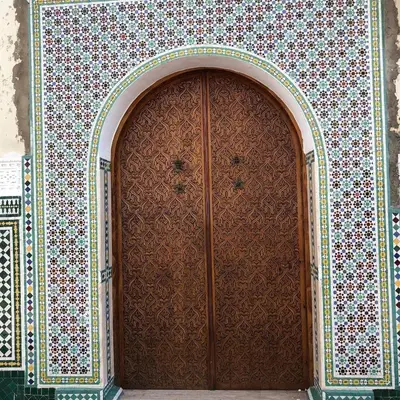a large wooden door in a wall with floral patterns at 3BR Authentic Apartment in the heart of Casablanca in Casablanca