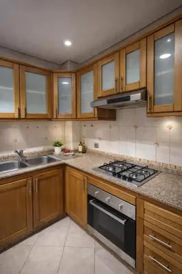 a kitchen with wooden cabinets and a stove top oven at 3BR Authentic Apartment in the heart of Casablanca in Casablanca
